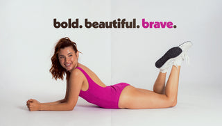 Model in a one piece POST SWIM magenta bathing suit with the words bold. beautiful. brave.