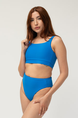 Front view of model wearing a POST SWIM blue bikini set with square neck bikini top and tummy control high waisted bikini bottom.
