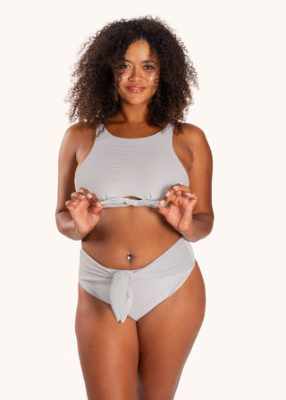 Woman wearing the Zoey Bikini Top in City Girl Stripe, front view showing the high neckline and center-chest knot detail.