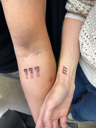 Lauren Yerkes and Chris Yerkes holding hands side by side, each with a matching 777 angel number tattoo on their wrist.