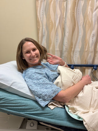 woman lying on a hospital bed smiling