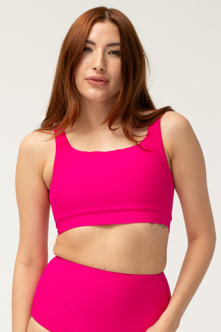 woman wearing a POST SWIM bikini top in bright pink
