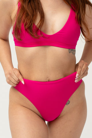 Front view of model wearing a POST SWIM pink bikini set with bikini top and tummy control high waisted bikini bottom.