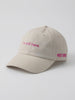 Video of the I'm Still Here Hat in stone, showing the pink 'i'm still here.' embroidery and POST SWIM logo