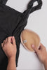 video of a breast prosthesis being placed into a black bathing suit on a white background